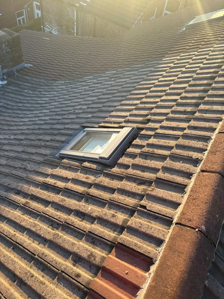 Brown concrete tile roof with a roof window fitted