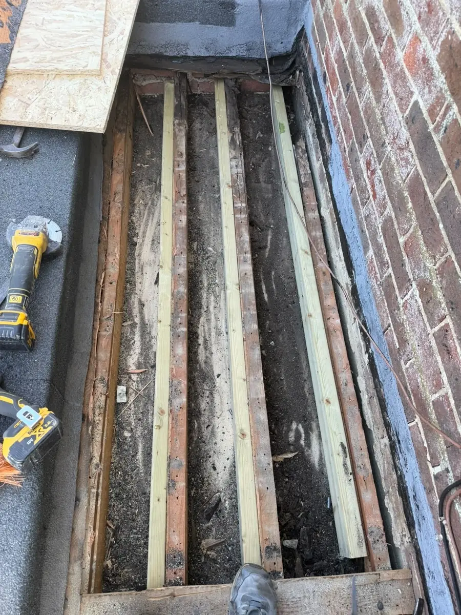 Flat roof stripped back to the joists before a new deck
