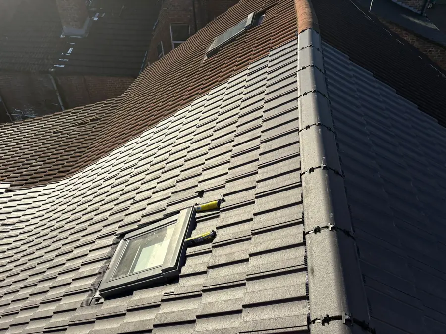 Grey tiled roof with a roof window and clean courses