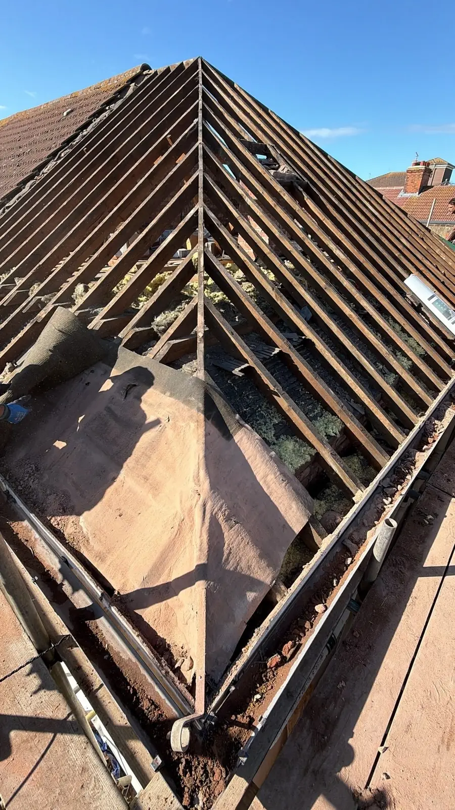 Hip roof stripped to the rafters with old battens showing