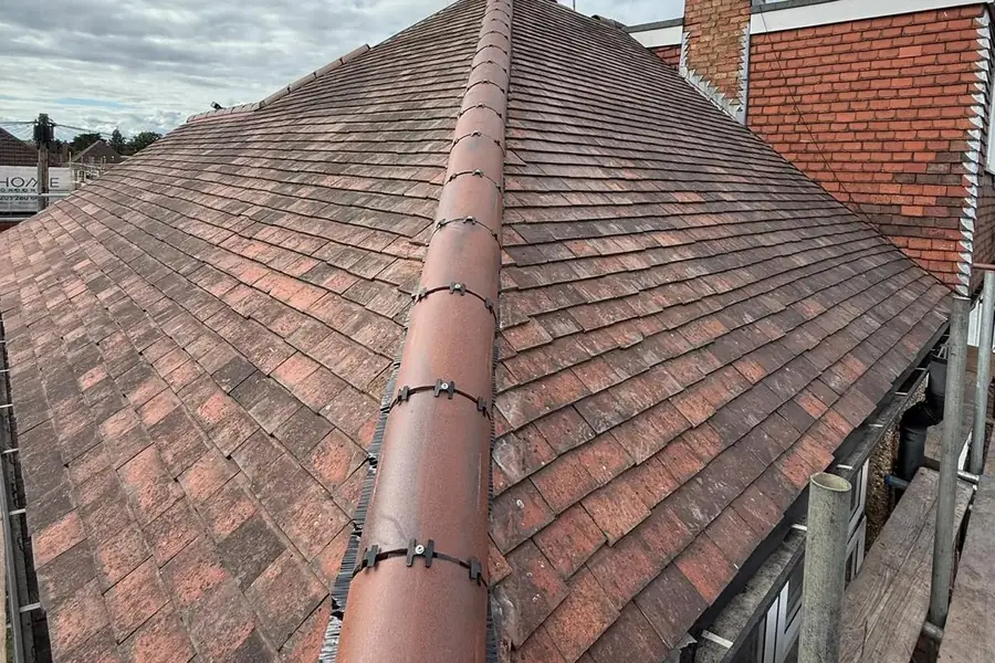 Brown plain tile hip roof with new ridge and hip tiles