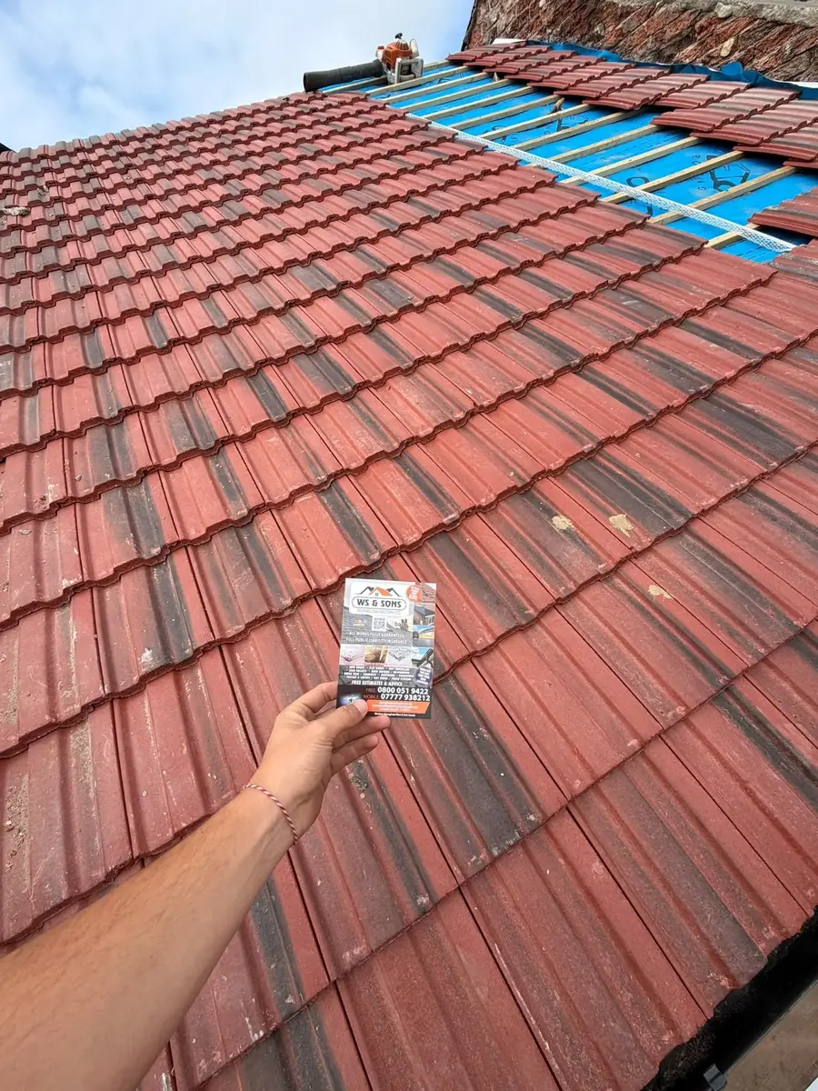 Red tile re-roof going on over blue membrane, flyer in shot