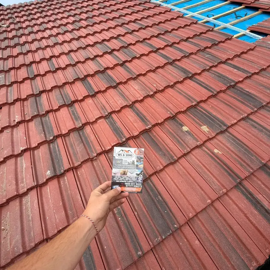 Red tile re-roof finished, WS & Sons flyer held in shot