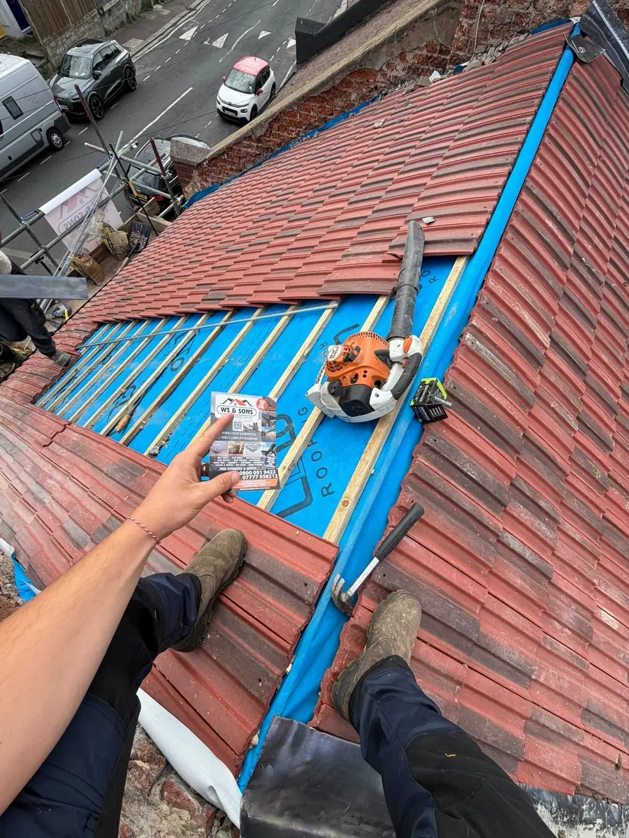 Red tiles laid up to the ridge, membrane still showing at the top