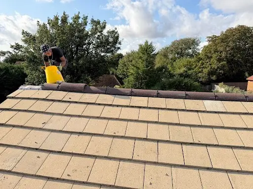 Roofer working along the ridge on freshly cleaned tiles