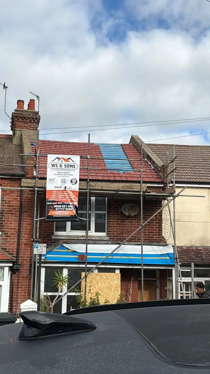 Scaffold on a house with the WS & Sons Roofing banner