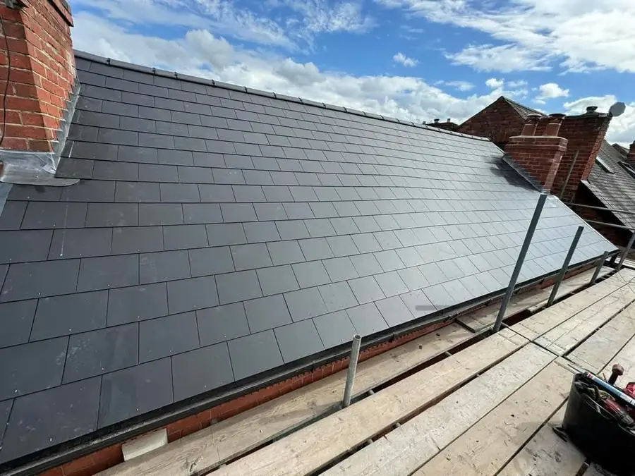 Long run of new slates on a terrace roof with chimney