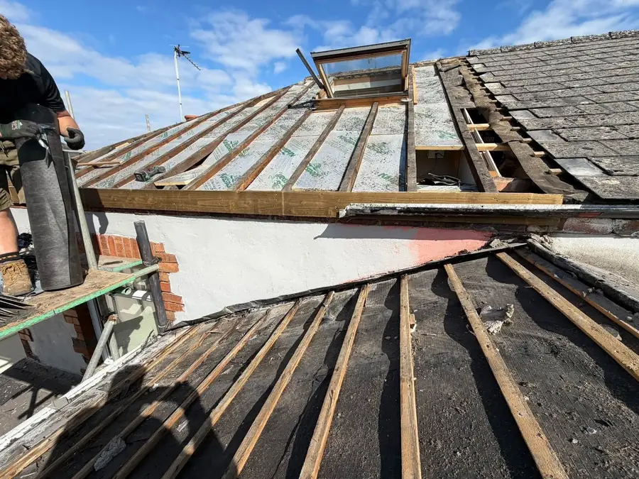 Roof stripped around a roof window before the new membrane
