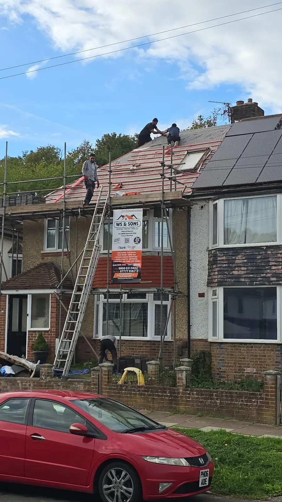 Crew on the roof of a scaffolded semi with the WS & Sons banner