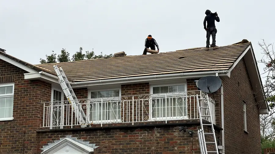 Two WS & Sons roofers at work on a tiled roof